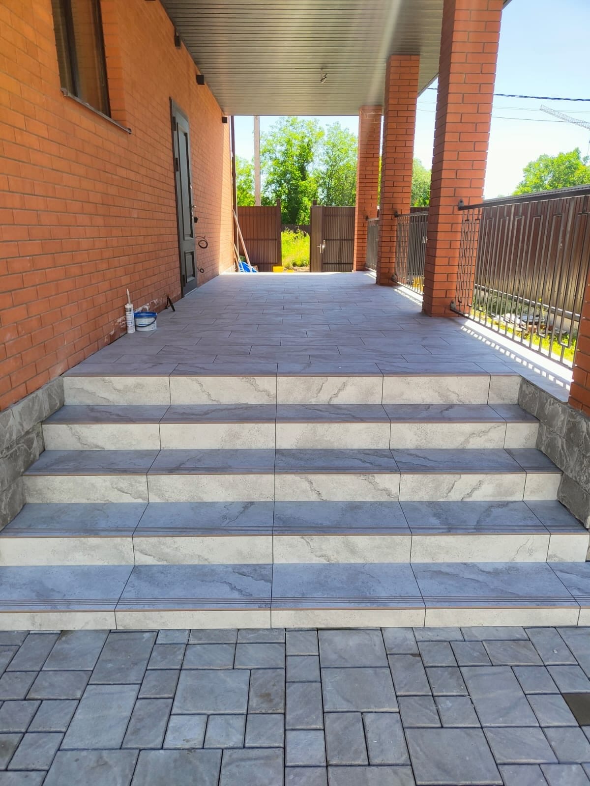 Nieuw betegelde terrastrap onder een overdekte veranda